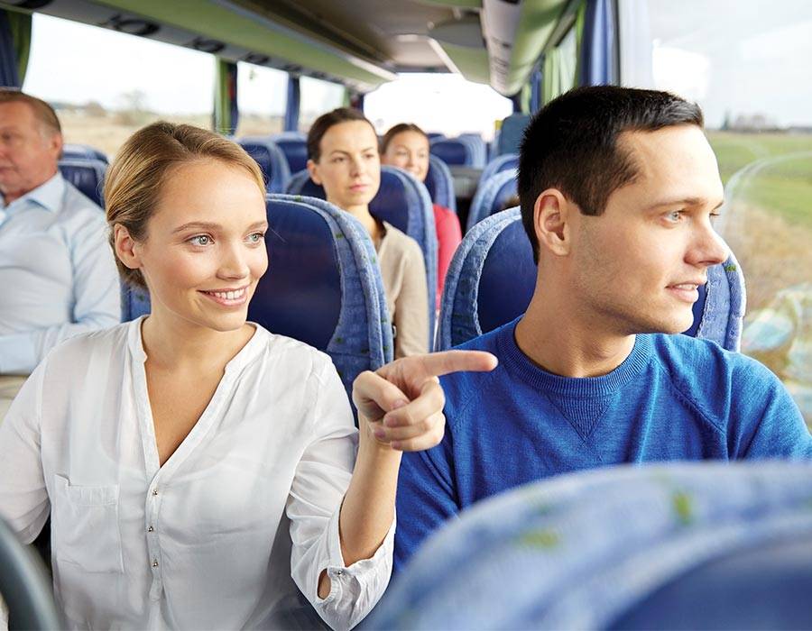 Woman pointing out of a window on a Shawnee Mass Transit bus with a man sitting beside her